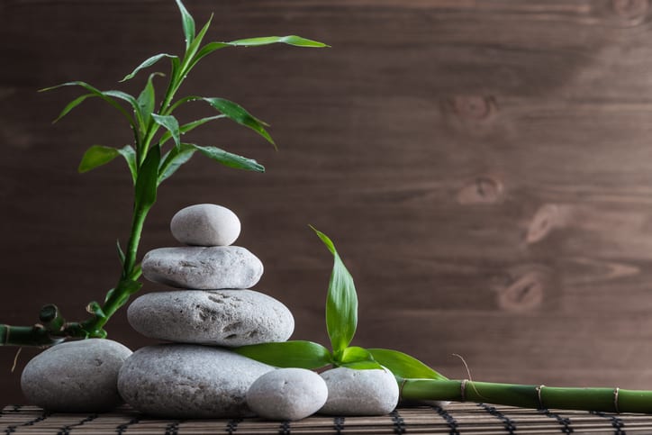 Zen balance stones and bamboo plant on the straw mat