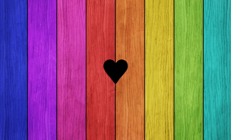Red heart hanging on white fence