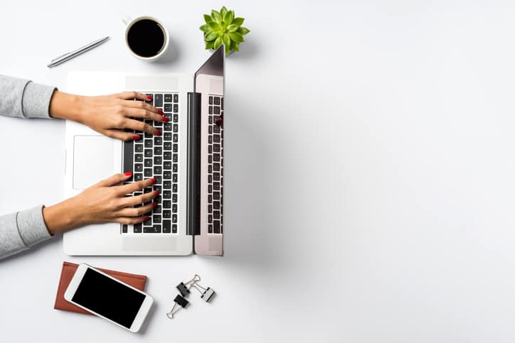 Female hands working on modern laptop. Office desktop on white background