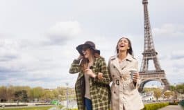 Carefree young women holding hands and having fun in Paris