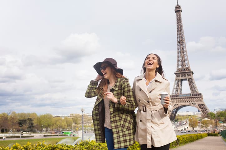 Carefree young women holding hands and having fun in Paris