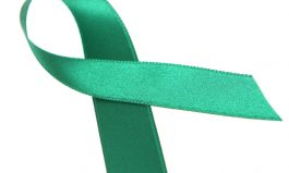 Green silk awareness ribbon on white background