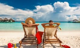 Couple in loungers on beach at Maldives