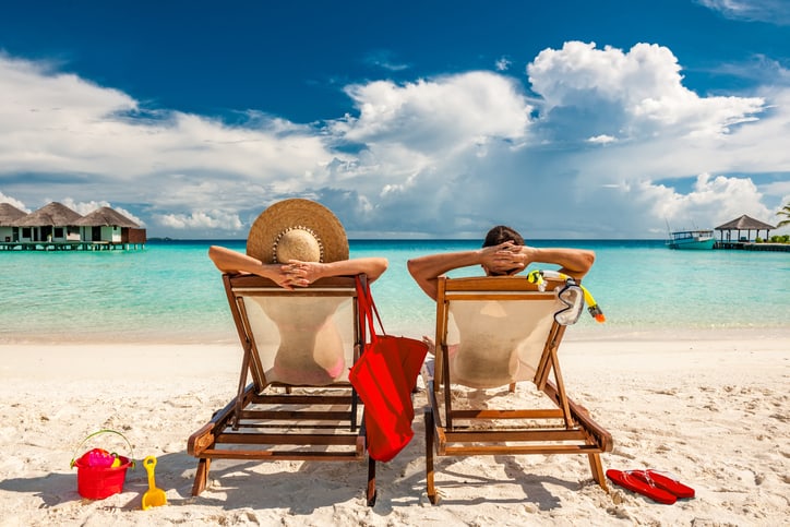 Couple in loungers on beach at Maldives