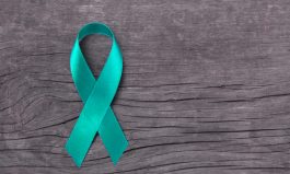 Teal ribbon awareness on woman's hand for Ovarian Cancer, Polycystic Ovary Syndrome (PCOS) disease, Post Traumatic Stress Disorder (PTSD), Tourette's Syndrome, Obsessive Compulsive Disorder (OCD)