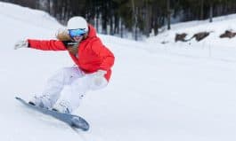 Ssnowboarder on slopes in the sunny morning