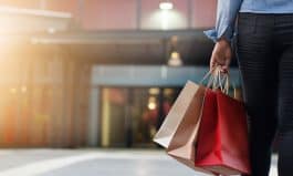 woman walking with shopping bags on shopping mall background